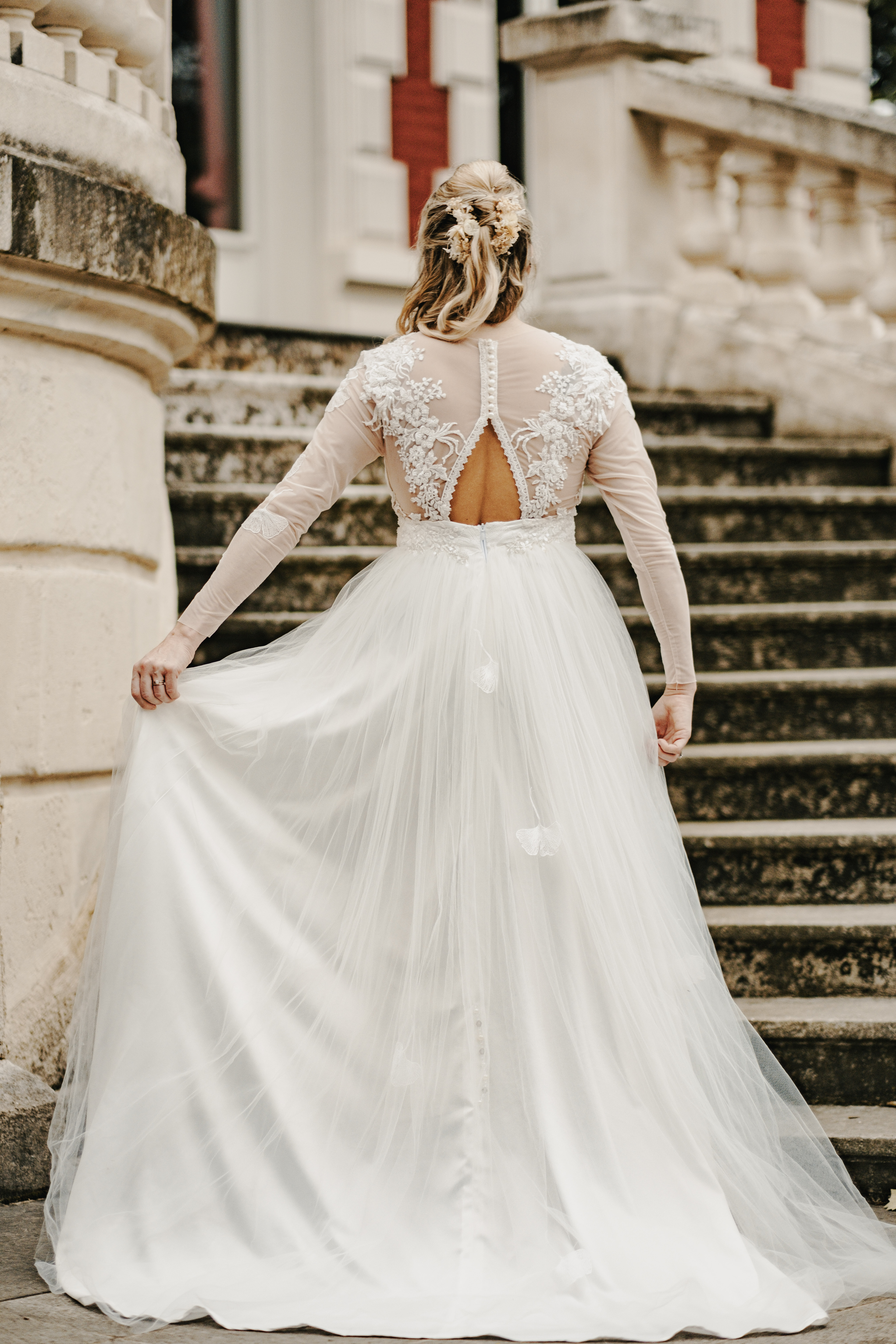 Une robe de mariée avec un joli dos ouvert, de la dentelle, des boutons nacrés